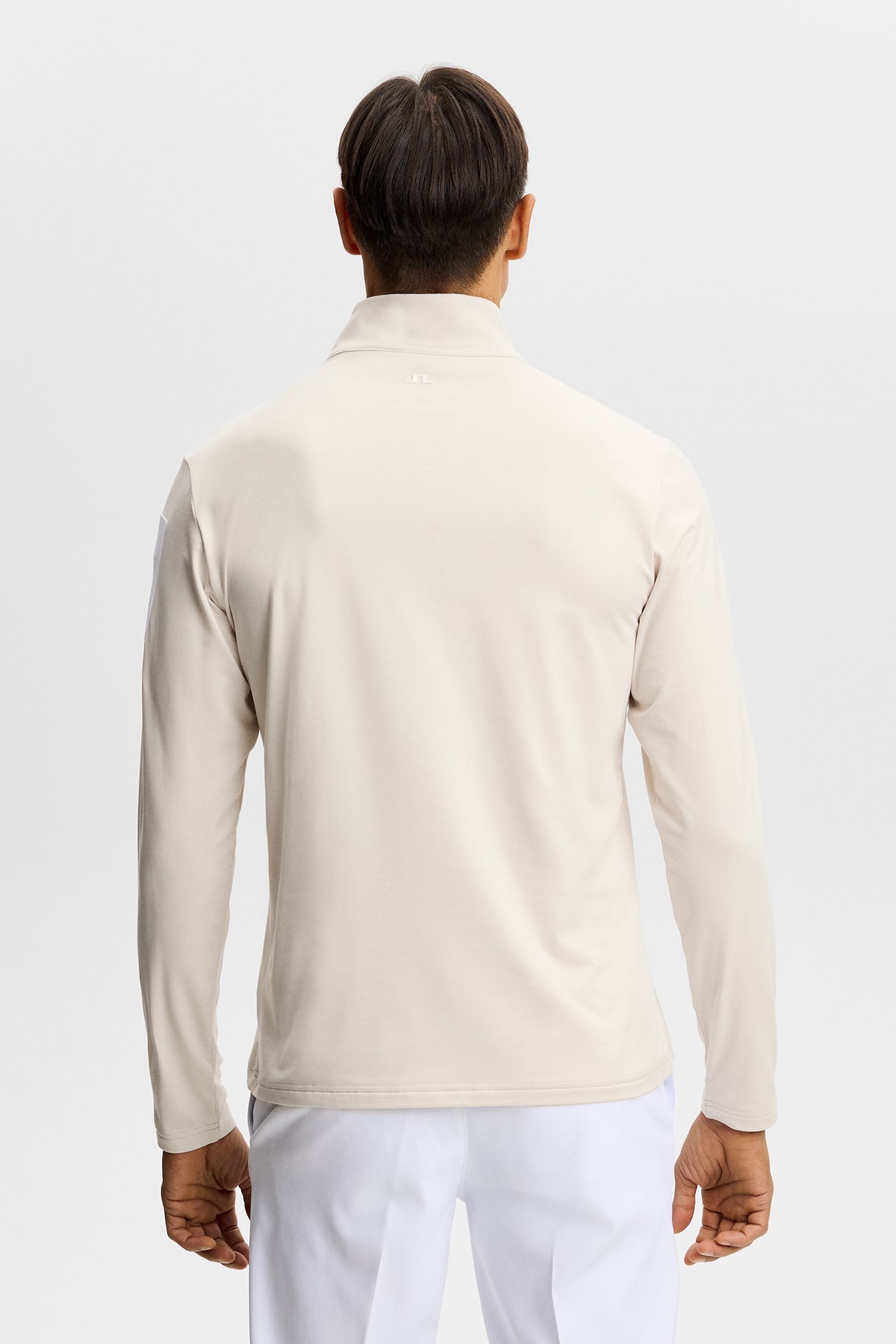Druga warstwa J.Lindeberg Keaton Quarter Zip Moonbeam – detal gumowego nadruku na rękawie i zamka 1/4