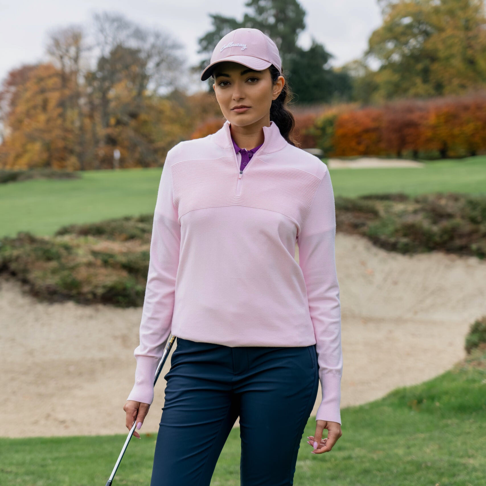 Golfistka w swetrze Callaway Soft Stretch Zip-Neck w kolorze Cherry Blossom na polu golfowym