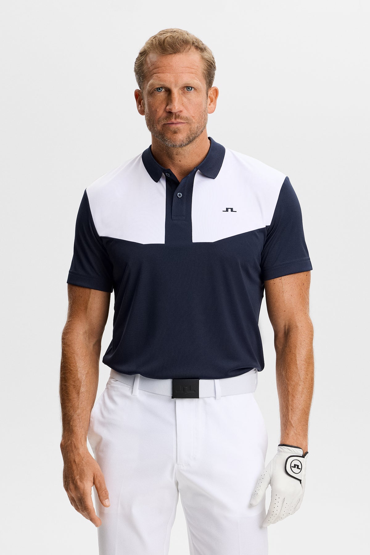 J.Lindeberg Calex Polo JL Navy – widok z przodu pokazujący kontrastowe panele na klatce piersiowej i logo Bridge